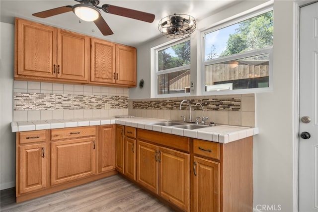 21964 Mojave River Rd, Cedarpines Park, CA 92322 - kitchen featuring a sink, decorative backsplash, light wood-type flooring, and a ceiling fan