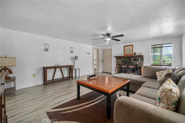 21964 Mojave River Rd, Cedarpines Park, CA 92322 - living area with a textured ceiling, light wood-type flooring, ceiling fan, and a fireplace