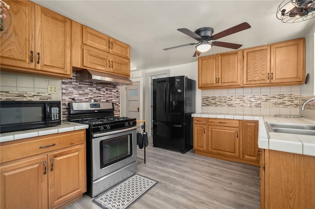 21964 Mojave River Rd, Cedarpines Park, CA 92322 - kitchen featuring black appliances, a sink, under cabinet range hood, and tile counters