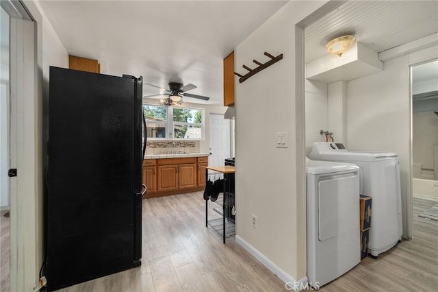 21964 Mojave River Rd, Cedarpines Park, CA 92322 - laundry area featuring washing machine and dryer, a ceiling fan, light wood finished floors, and baseboards