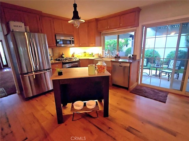 3889 Acorn Ct, Simi Valley, CA 93063 - kitchen with stainless steel appliances, a sink, light wood-type flooring, decorative light fixtures, and a kitchen island