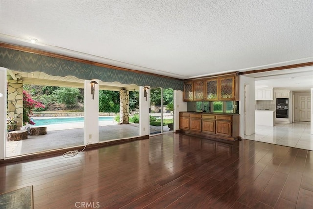 2484 Chauncy Pl, Riverside, CA 92506 - unfurnished living room featuring a textured ceiling, wood finished floors, and ornamental molding