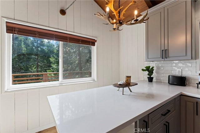 698 W Victoria Ct, Lake Arrowhead, CA 92352 - kitchen with light countertops, a chandelier, gray cabinetry, hanging light fixtures, and decorative backsplash