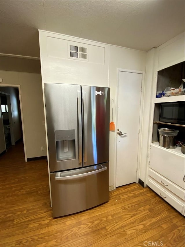 560 Silver Leaf Dr, Oroville, CA 95966 - kitchen featuring stainless steel fridge, wood finished floors, and black microwave