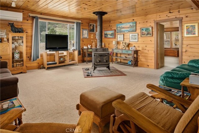 9000 Figueroa Mountain Rd, Los Olivos, CA 93441 - carpeted living area with a wall mounted air conditioner, wood walls, wooden ceiling, and a wood stove