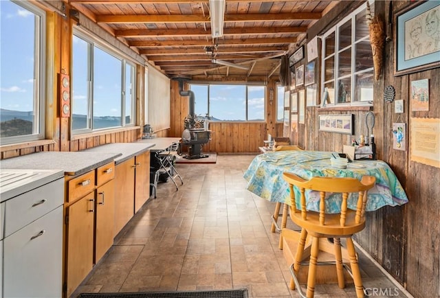 9000 Figueroa Mountain Rd, Los Olivos, CA 93441 - sunroom featuring wooden ceiling, wooden walls, a wood stove, healthy amount of natural light, and beam ceiling