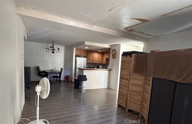 living area featuring dark wood-type flooring, a chandelier, and a textured ceiling