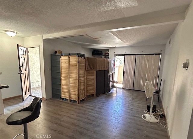 below grade area featuring wood finished floors, a textured ceiling, and baseboards
