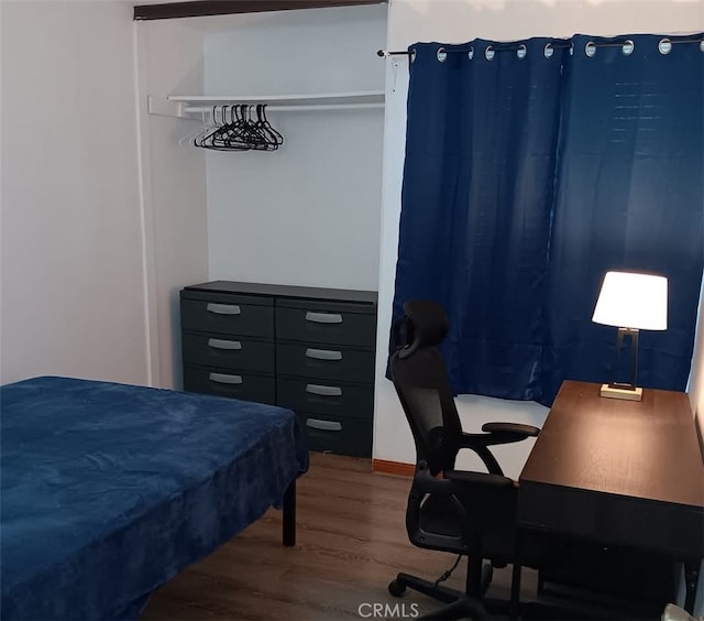 bedroom with wood finished floors and a desk