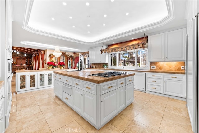 1782 Chota Rd, La Habra Heights, CA 90631 - kitchen with stainless steel gas stovetop, a tray ceiling, a warming drawer, white cabinets, and recessed lighting