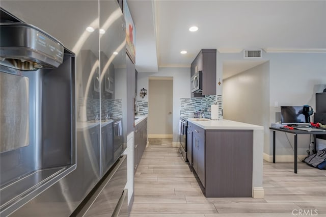 1517 E Garfield Ave Unit 94, Glendale, CA 91205 - kitchen featuring appliances with stainless steel finishes, crown molding, light countertops, decorative backsplash, and light wood-type flooring