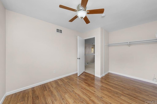 unfurnished bedroom with wood finished floors, baseboards, and a ceiling fan