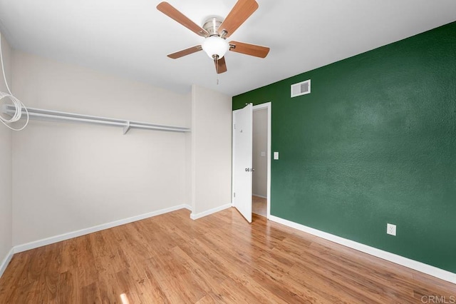 unfurnished bedroom with wood finished floors, baseboards, and a ceiling fan