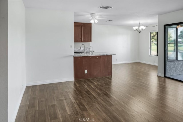 kitchen with dark wood-style floors, a chandelier, open floor plan, and a ceiling fan