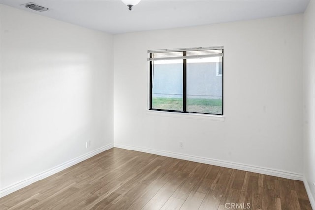 unfurnished room featuring wood finished floors and baseboards