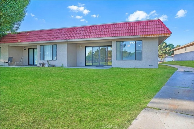 27535 Lakeview Dr Unit 37, Helendale, CA 92342 - rear view of house featuring stucco siding, a tiled roof, and a lawn