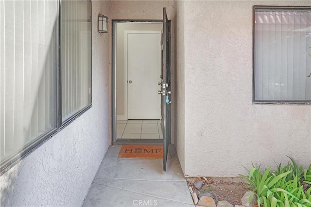 view of exterior entry with stucco siding