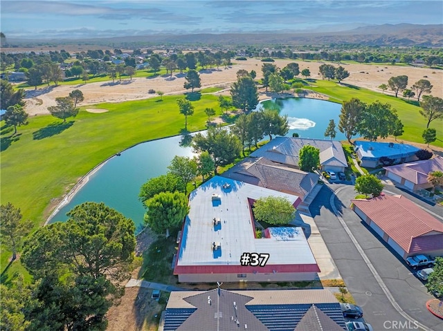 drone / aerial view of a nearby body of water and a golf course