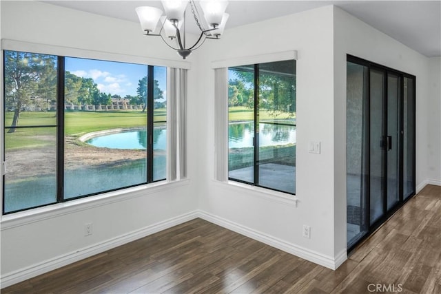 unfurnished dining area with dark wood-type flooring, baseboards, and a chandelier