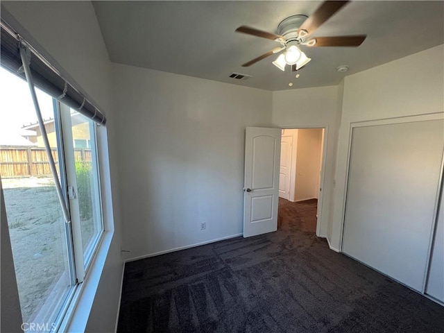 12418 Firefly Way, Victorville, CA 92392 - unfurnished bedroom featuring multiple windows, carpet floors, a ceiling fan, and access to exterior