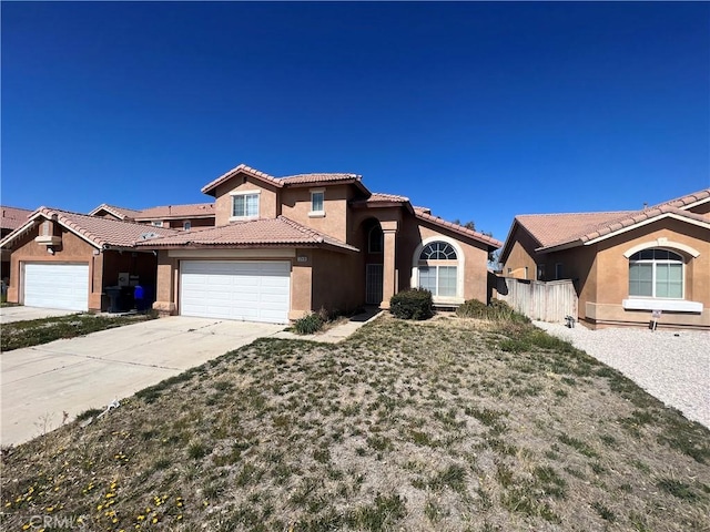 12418 Firefly Way, Victorville, CA 92392 - view of front of home with stucco siding, a garage, a tiled roof, concrete driveway, and fence