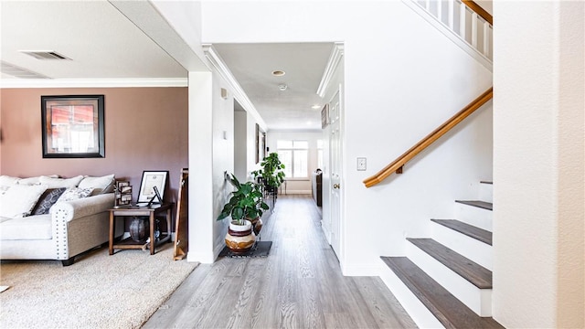 entrance foyer featuring stairway, wood finished floors, crown molding, and baseboards