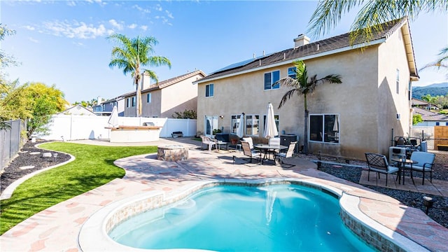 rear view of house featuring a fenced backyard, stucco siding, and a patio area