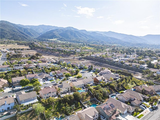 aerial view of property's location with nearby suburban area and a mountainous background
