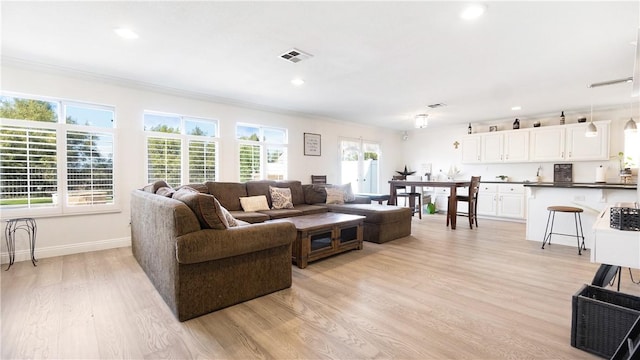 living room featuring light wood-style floors, recessed lighting, and baseboards