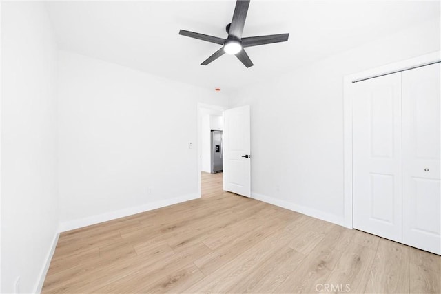 9613 Wilmington Ave, Los Angeles, CA 90002 - unfurnished bedroom with stainless steel refrigerator with ice dispenser, light wood-style floors, baseboards, a closet, and a ceiling fan