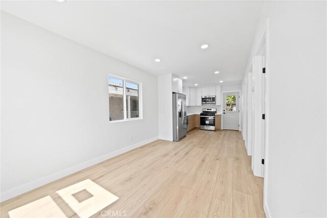 9613 Wilmington Ave, Los Angeles, CA 90002 - unfurnished living room with light wood-type flooring, baseboards, and recessed lighting