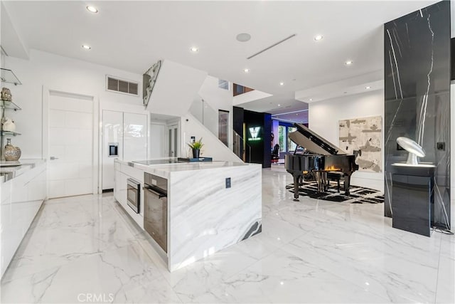4841 Alonzo Ave, Encino, CA 91316 - kitchen with modern cabinets, oven, light stone counters, a spacious island, and recessed lighting