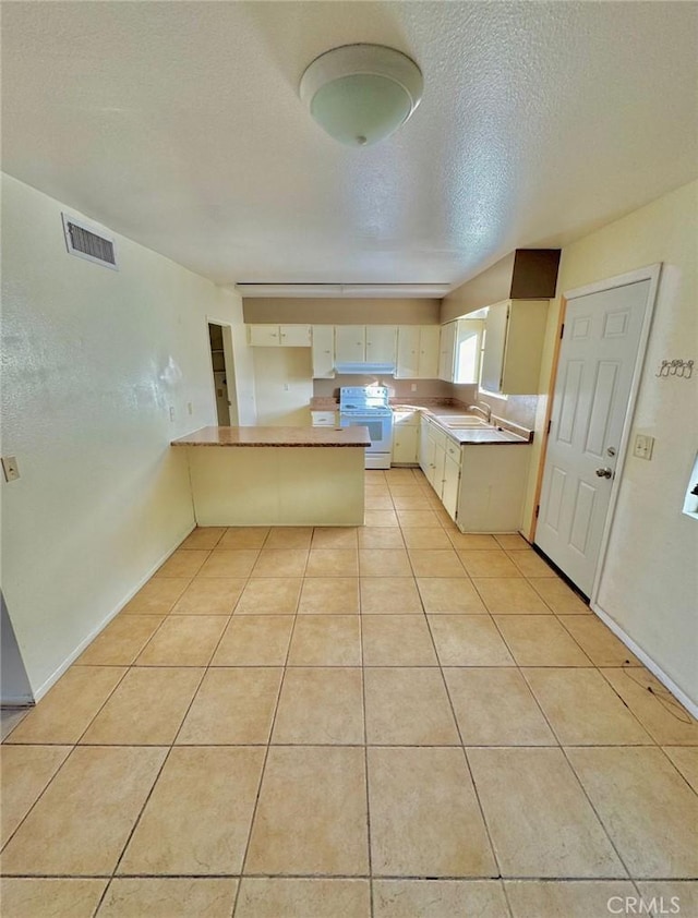 1060 N Lovekin Blvd Unit 2, Blythe, CA 92225 - kitchen with white range with electric cooktop, a peninsula, a sink, light tile patterned floors, and a textured ceiling