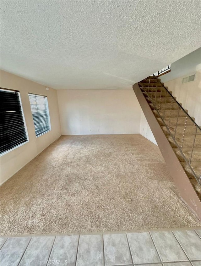 1060 N Lovekin Blvd Unit 2, Blythe, CA 92225 - unfurnished living room featuring carpet, a textured ceiling, and stairs