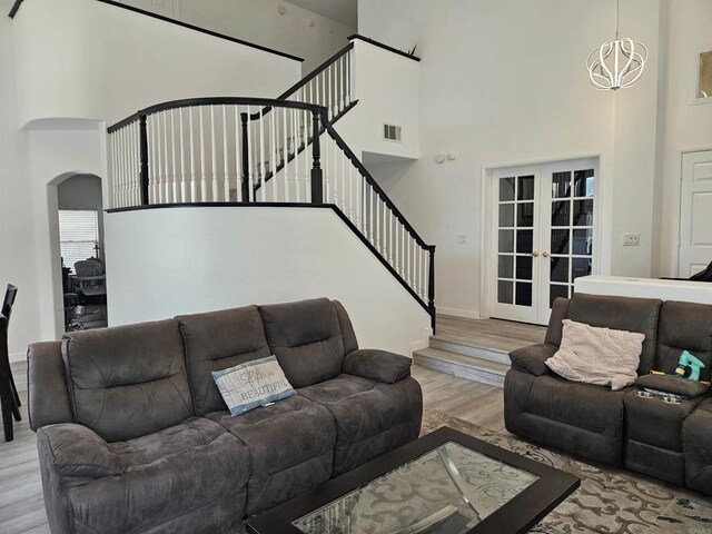 43075 Corte Fresca, Temecula, CA 92592 - living room with a high ceiling, stairway, french doors, wood finished floors, and arched walkways