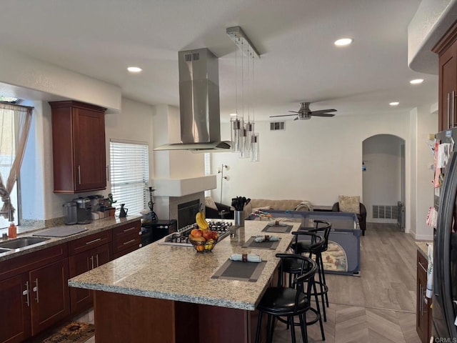 43075 Corte Fresca, Temecula, CA 92592 - kitchen featuring island range hood, open floor plan, a breakfast bar area, ceiling fan, and stainless steel appliances