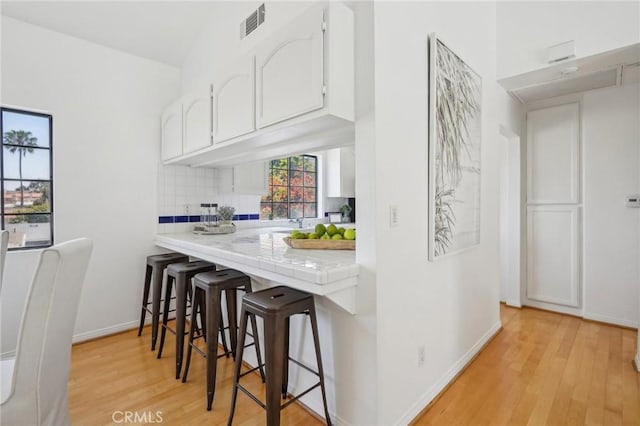 1924 Mathews Ave Unit B, Redondo Beach, CA 90278 - bar area featuring light wood-style flooring, tasteful backsplash, and baseboards