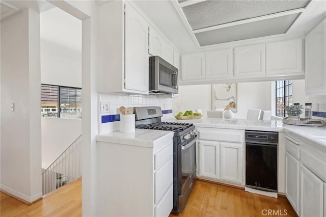 1924 Mathews Ave Unit B, Redondo Beach, CA 90278 - kitchen featuring appliances with stainless steel finishes, tile counters, light wood-type flooring, and white cabinetry
