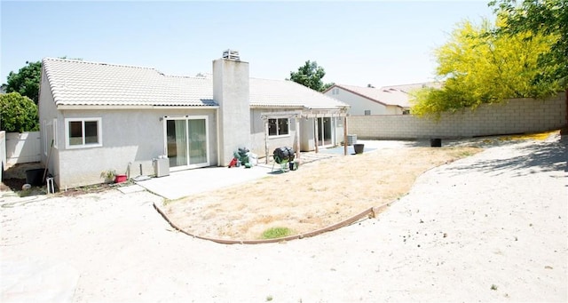 5538 Katrina Pl, Palmdale, CA 93552 - back of house featuring a chimney, a fenced backyard, a patio area, a tiled roof, and stucco siding