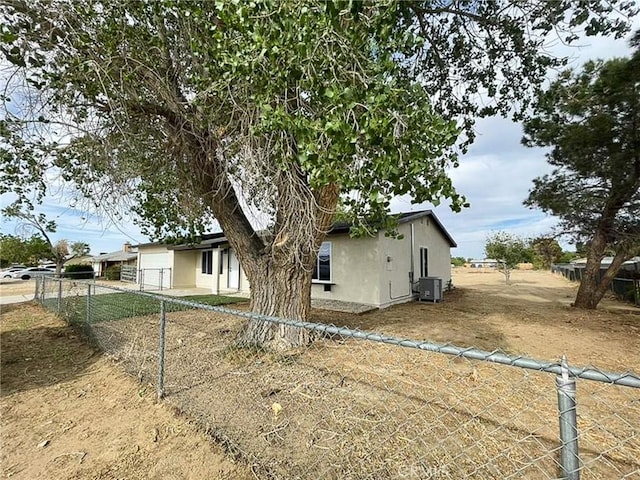 view of property exterior with cooling unit, stucco siding, an attached garage, and driveway