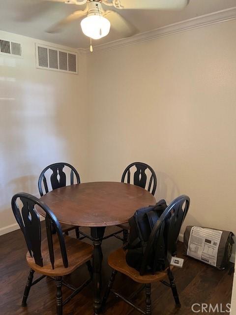dining area featuring wood finished floors, ornamental molding, baseboards, and ceiling fan