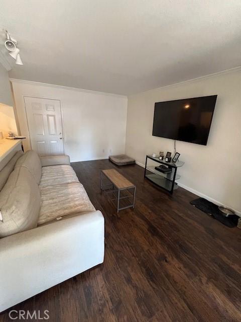 living area featuring wood finished floors and ornamental molding