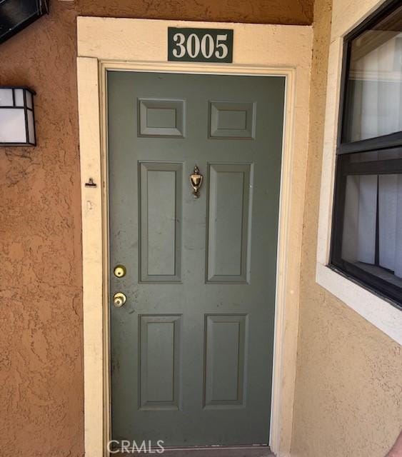 entrance to property featuring stucco siding