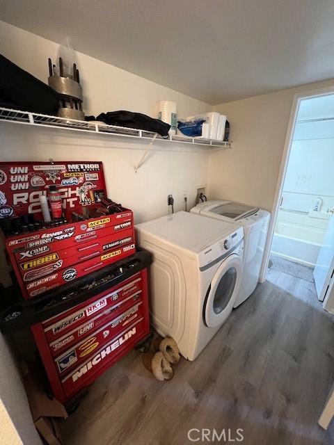 washroom with wood finished floors and separate washer and dryer