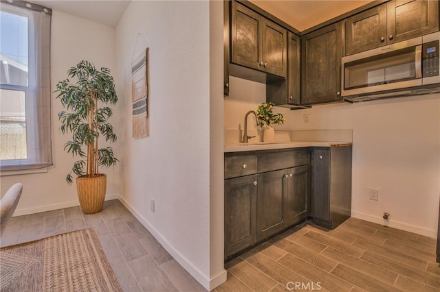 interior space with wood tiled floors, plenty of natural light, a sink, and baseboards