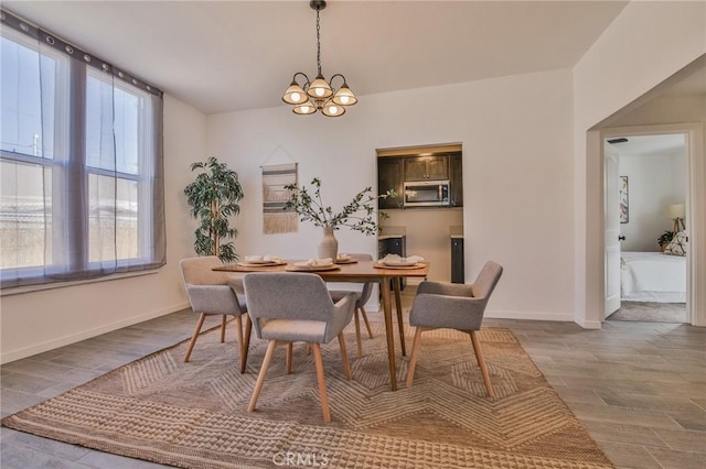 dining area with wood finished floors, a chandelier, and baseboards