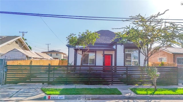 bungalow featuring a fenced front yard and a gate