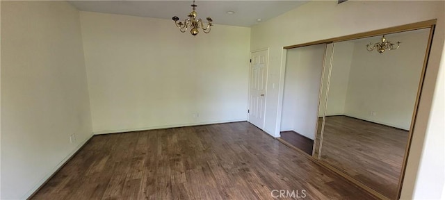 unfurnished dining area with a chandelier, wood finished floors, and baseboards