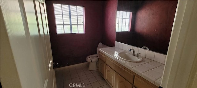 bathroom featuring tile patterned flooring, vanity, toilet, and baseboards