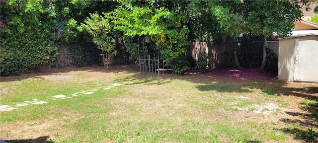 view of grassy yard with a storage unit and an outdoor structure